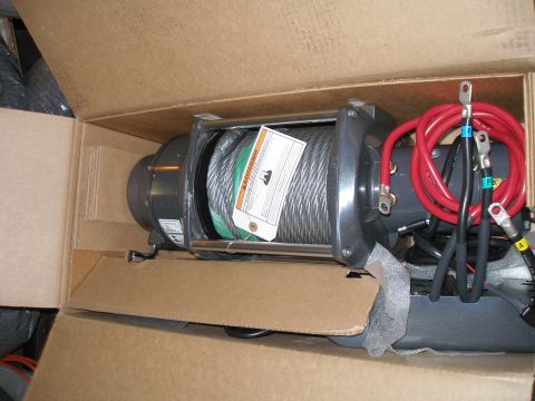 1984 Ford Bronco - A new winch, still in its shipping box, with thick red power cables attached.