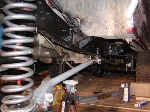 1991 Ford Bronco - Close-up view of the undercarriage and suspension system of a vehicle, possibly undergoing modification or repair.