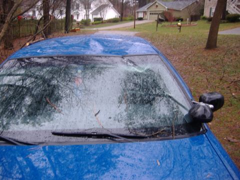 1998 Ford Crown Victoria - A blue 1998 Ford Crown Victoria shows a heavily damaged windshield with debris on it.