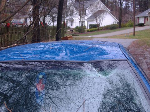 1998 Ford Crown Victoria - The blue car's roof shows significant damage, and the windshield is cracked, indicating it may have been involved in an incident.