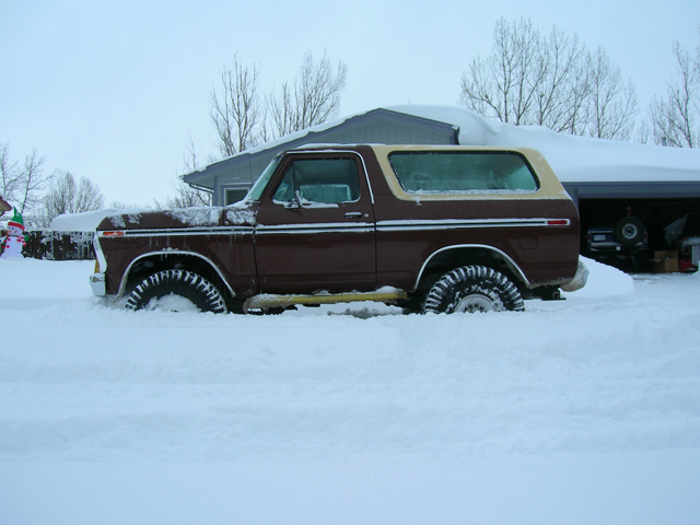 Brown 1979 Ford Bronco stuck in deep snow, side view