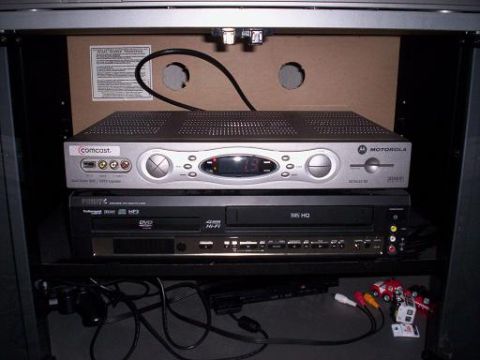 1989 Ford Bronco - A collection of home entertainment electronics and their associated wiring are neatly organized within a cabinet.