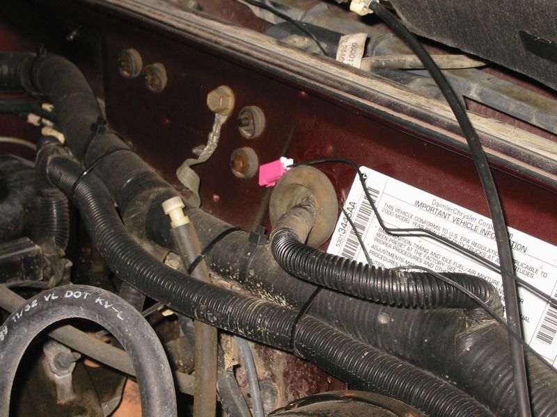 Detail showing the routing of the antenna lead through the grommet that carries the wiring for the wiper motor from the engine bay to the cowl.