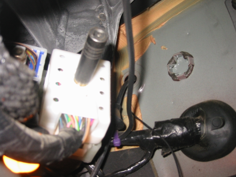 Detail showing the grommet around the hood release cable (look to the left of the plug in the bulkhead) that was removed to drop the antenna into the cabin.