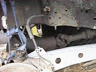 1986 Ford Bronco - Close-up view of a vehicle's undercarriage, a SuperMotors.net logo.