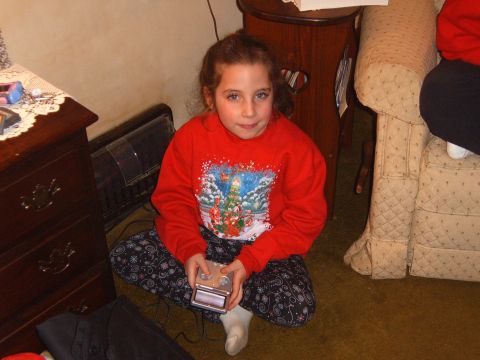 1993 Ford Bronco - A young girl sits on the floor, engrossed in her handheld video game console during what appears to be a holiday gathering.