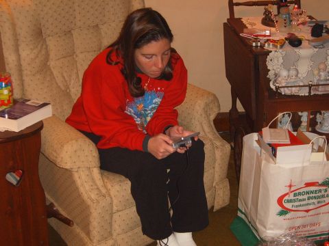 1993 Ford Bronco - A woman sits in a recliner, engrossed in a handheld video game, with Christmas decorations visible in the background.