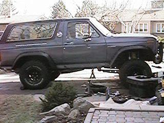 1986 Ford Bronco - This lifted SUV is shown on jack stands, suggesting maintenance or modification work is underway. Its body style points to an early 1980s m…