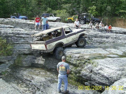 1979 Ford Bronco - Several off-road vehicles navigate a rocky, water-filled landscape.