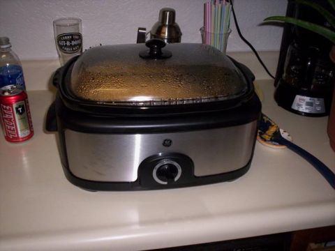1989 Ford Bronco - A GE slow cooker is shown on a kitchen counter next to a beverage can and a glass.