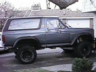 1986 Ford Bronco - Side view of a lifted Ford Bronco with aftermarket wheels and tires.