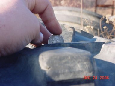 1977 Ford F-250 - Checking tire tread depth with a coin.