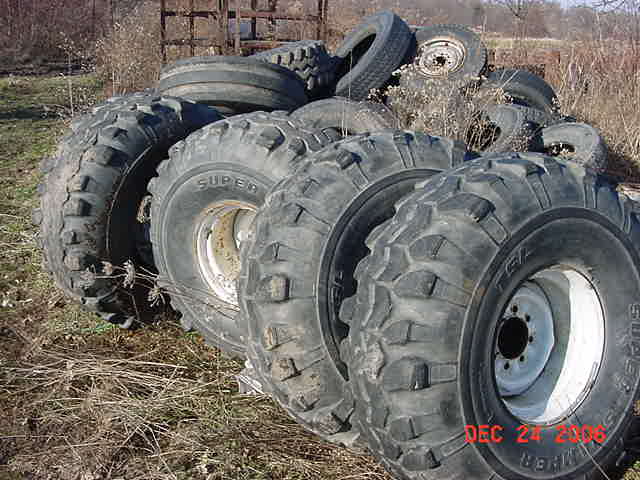 Pile of off-road tires with visible text 'SUPERMOTORS'