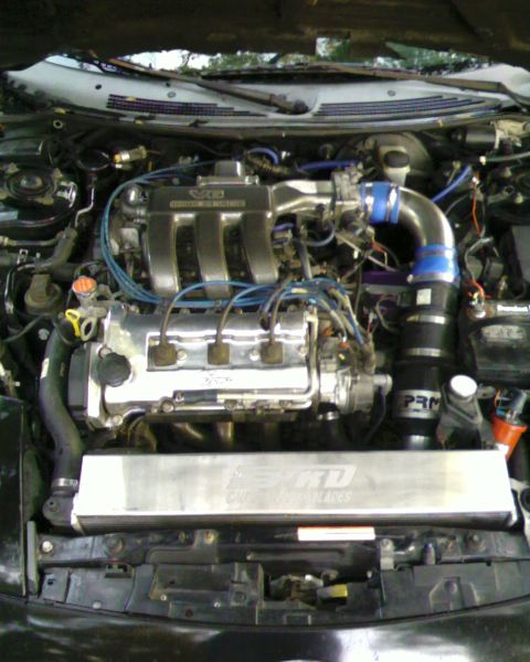 1996 Ford Probe - The engine bay shows a V6 engine with aftermarket modifications like an intake and intercooler.