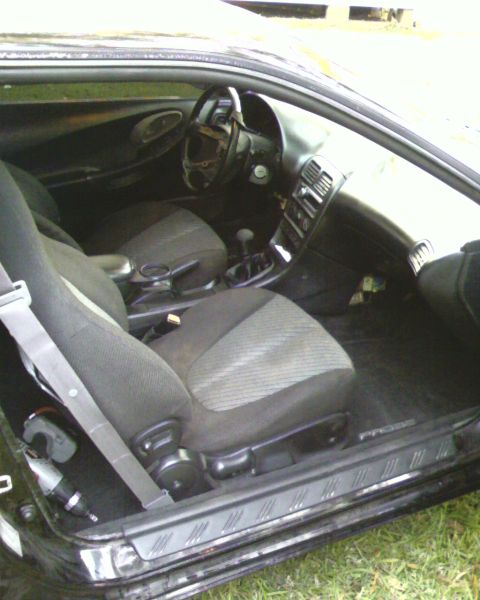 1996 Ford Probe - Interior view of a car, showing the seats and dashboard. The word "PROBE" is visible on the door sill.