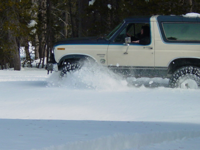1986 Ford Bronco side view driving through snow