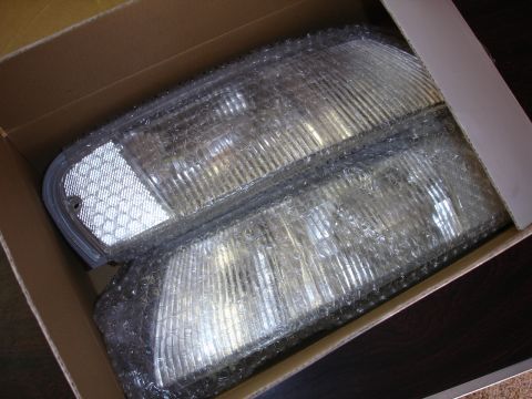 1993 Ford Taurus - New car headlights are packaged in bubble wrap and a cardboard box.