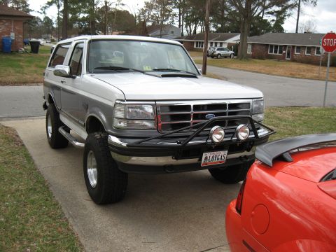 1994 Ford Bronco - This 1994 Ford Bronco features a two-tone paint scheme and a prominent brush guard with auxiliary lights.