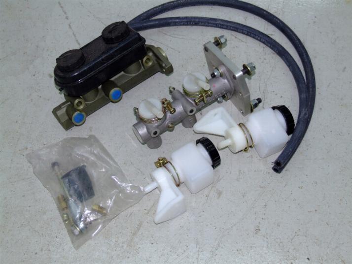 brake master cylinder, reservoir, and hoses laid out on a concrete surface