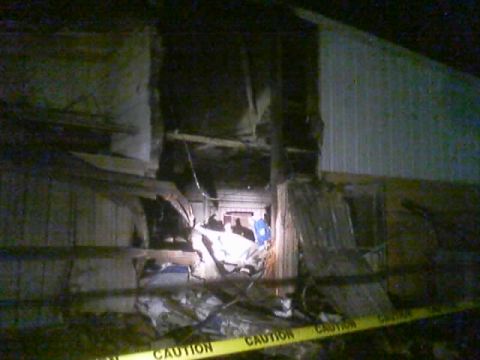 1989 Ford Bronco - The interior of a building shows significant damage, with caution tape stretched across the scene.