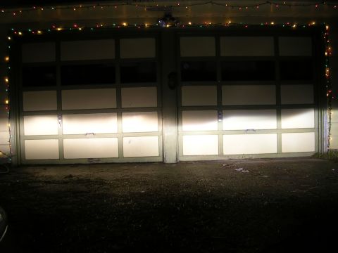 2004 Mazda 6 - Headlights shine on garage doors decorated with string lights.
