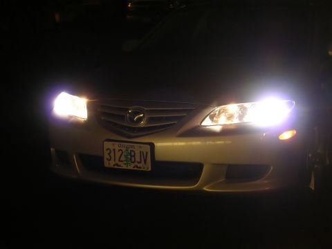 2004 Mazda 6 - The front grille and headlights of a 2004 Mazda 6 are illuminated at night.