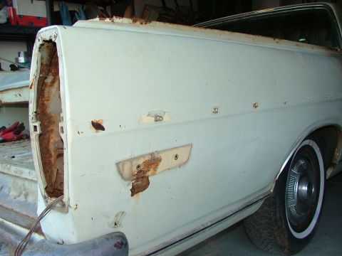 1969 Ford Ranchero - Rear section of a 1969 Ford Ranchero, showing significant rust on the tailgate and bed panel.