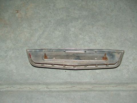 1969 Ford Ranchero - This chrome trim piece, possibly from a vehicle's tailgate or bed, is shown against a concrete surface.