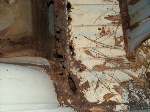 1969 Ford Ranchero - Extensive rust and debris are visible on the bed and frame of this vehicle, indicating severe deterioration.