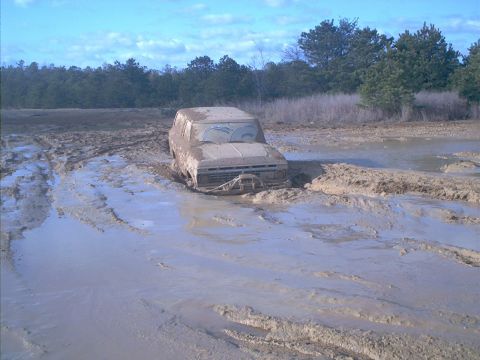 1978 Ford Bronco - This vehicle is deeply stuck in a muddy area, with only the top half visible above the muck.