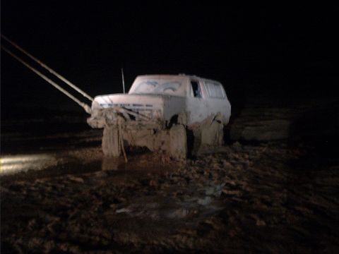 1978 Ford Bronco - This vehicle is deeply mired in mud, with tow ropes extending from its front.