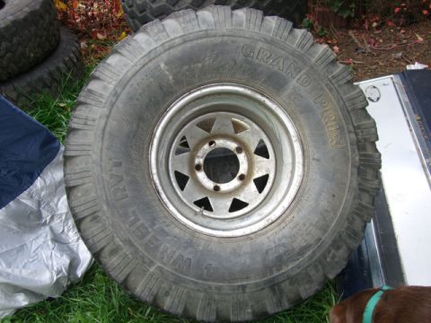 1986 Ford Bronco - A close-up of a large off-road tire and wheel assembly is shown, with other tires in the background.