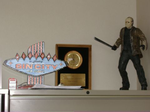 1991 Ford Bronco - A shelf displays a Jason Voorhees figurine, a 'Sin City' sign, and a framed clock.