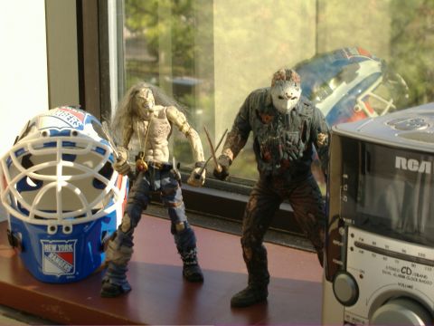 1991 Ford Bronco - Two action figures stand next to a New York Rangers hockey mask on a windowsill, with a radio and a blurred object in the background.