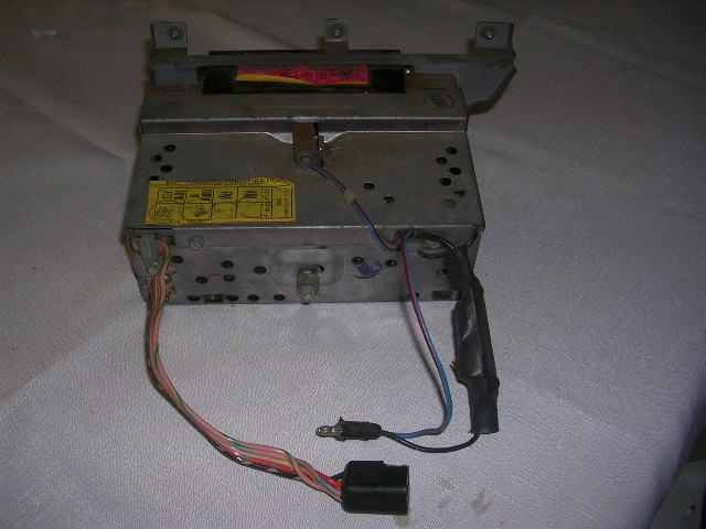 Back of a car radio with wires and a yellow sticker showing diagrams