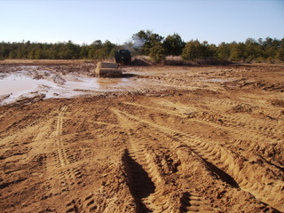 1978 Ford Bronco - An off-road vehicle navigates a challenging muddy terrain under a clear sky.