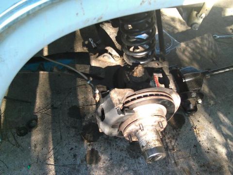 1986 Ford Bronco - This image shows a close-up view of a vehicle's suspension and brake system, focusing on the coil spring and brake rotor.