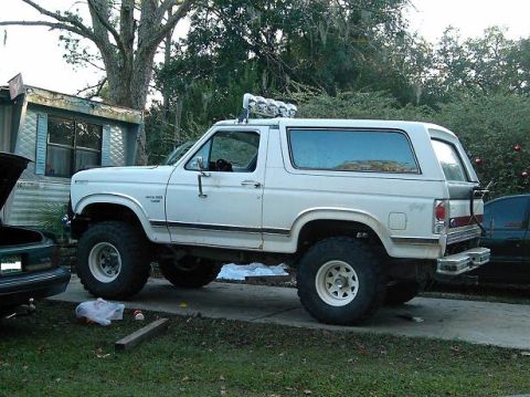 1986 Ford Bronco - This lifted 1986 Ford Bronco features a prominent suspension lift and auxiliary lights mounted on the roof.