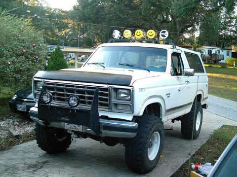 1986 Ford Bronco - This modified Ford Bronco features a lifted suspension, custom bumper, and unique roof-mounted lights.
