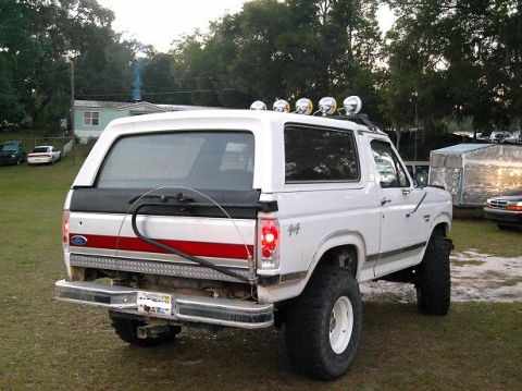 1986 Ford Bronco - This lifted Ford Bronco features a spare tire carrier and a light bar, suggesting it's ready for off-road adventures.