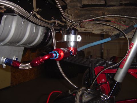 1978 Ford Bronco - Close-up view of custom fuel lines and a red shock absorber mounted to the undercarriage of a vehicle.