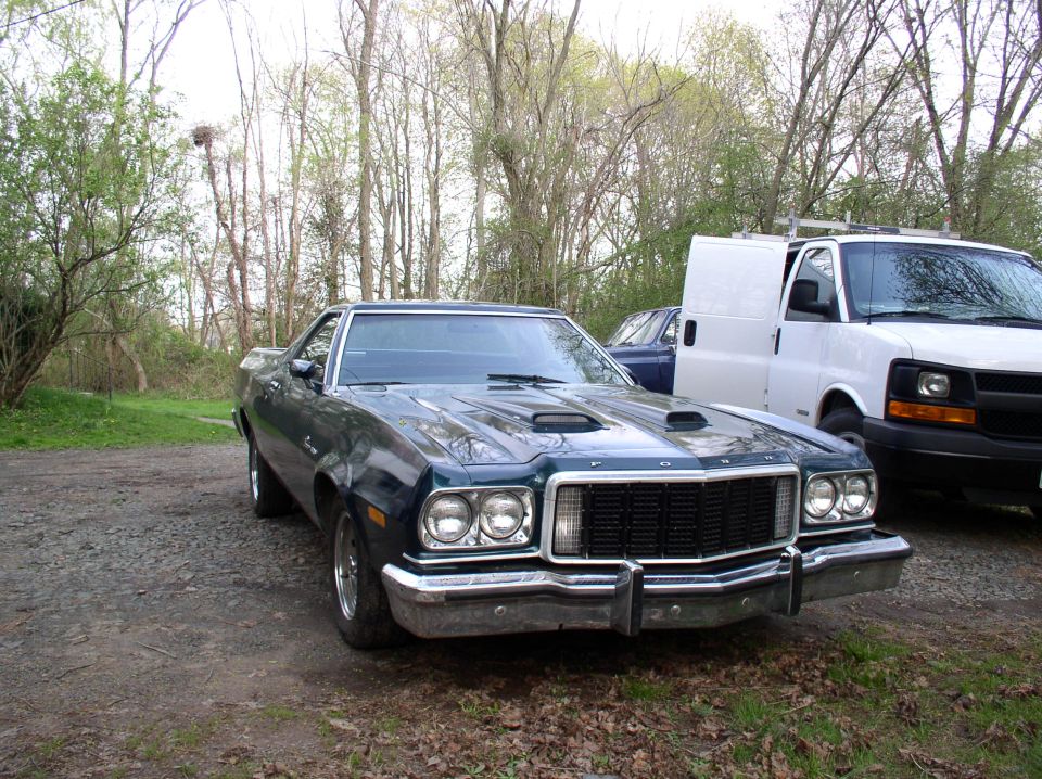 Dark green 1973 Ford Ranchero with hood scoops parked outdoors