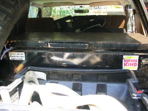 1986 Ford Bronco - Interior view of a vehicle, showing a spare tire and two stickers on the rear panel.