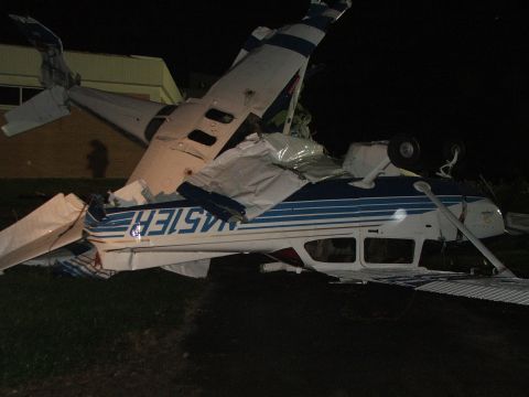 1989 Ford Bronco - A crashed airplane lies on the ground at night, showing significant damage to its structure.