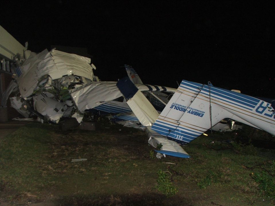 Wrecked Embry-Riddle training aircraft piled on grass at night