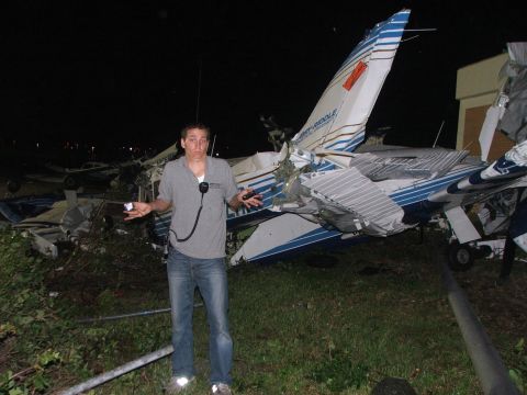 1989 Ford Bronco - A person stands in front of a severely damaged airplane, with other damaged aircraft visible in the background at night.