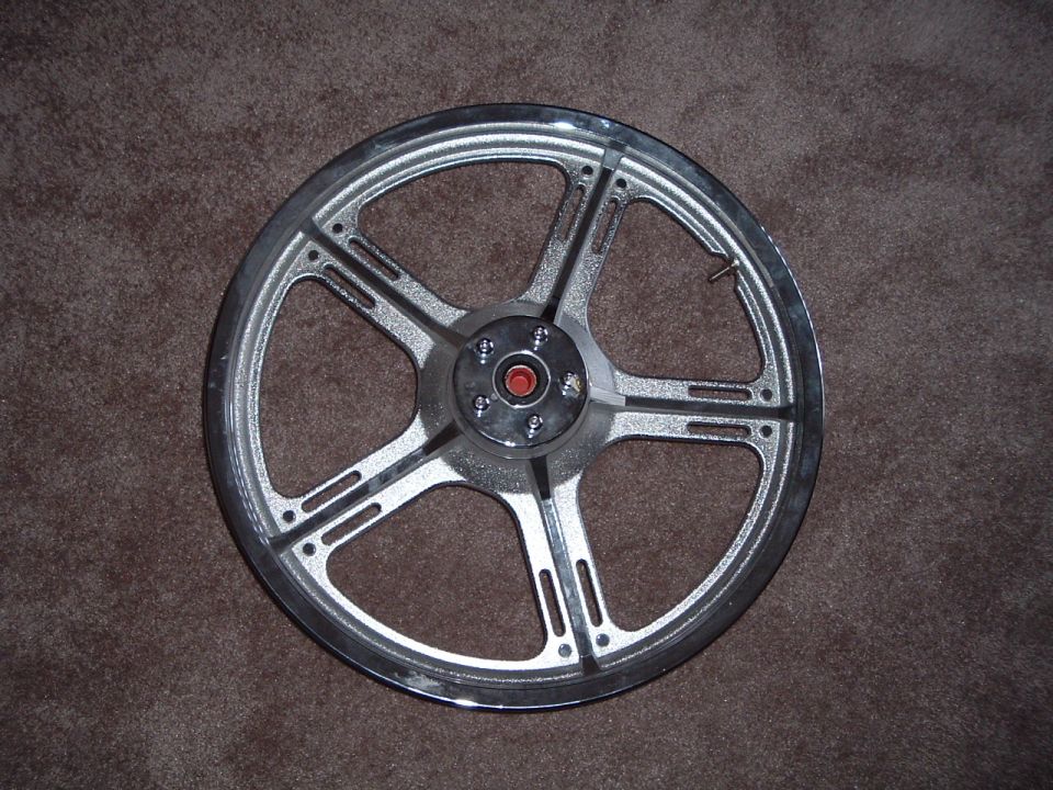 Chrome motorcycle wheel with five spokes, each having two slots
