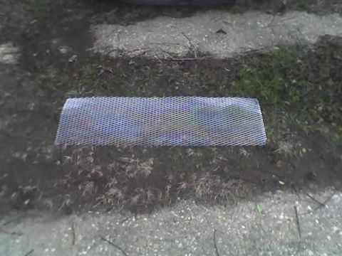 2000 Ford Escort - A piece of car grille mesh is shown on the ground, possibly for a 2000 Ford Escort ZX2.