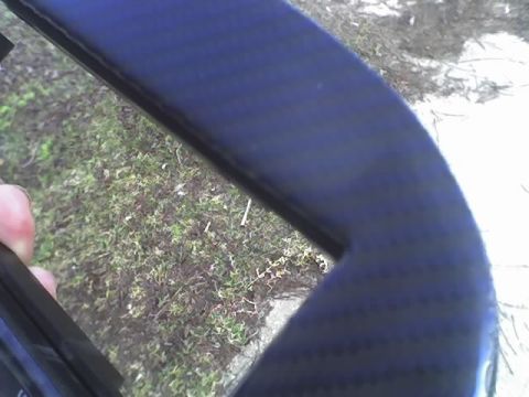 2000 Ford Escort - Close-up of a dark blue interior car trim piece against a background of grass and dirt.