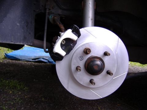 1998 Ford Taurus - A close-up view of a vehicle's brake system, highlighting a new slotted rotor and a white caliper.